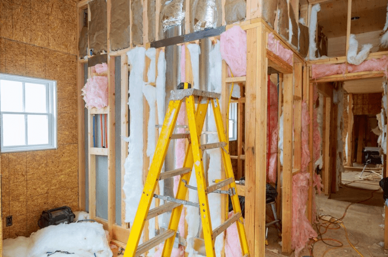 A house under construction with old insulation being removed.Â
