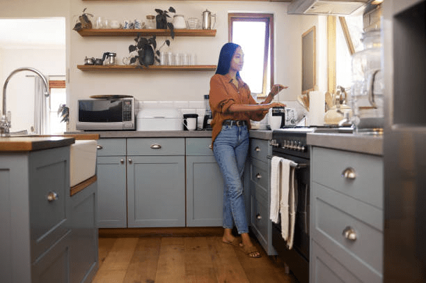 A woman makes coffee in her well-insulated kitchen. 