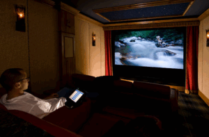 An image of a man watching a movie in his home theater room.