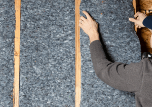 A worker installing Quiet Denim’s recycled denim insulation.