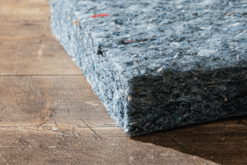 A close up of blue denim insulation lying on a floor.