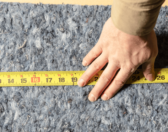 Close-up of denim insulation being measured to ensure a precise fit.