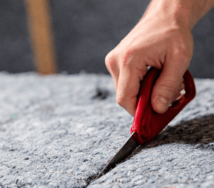 Insulation tools in use for cutting and fitting denim insulation batts.